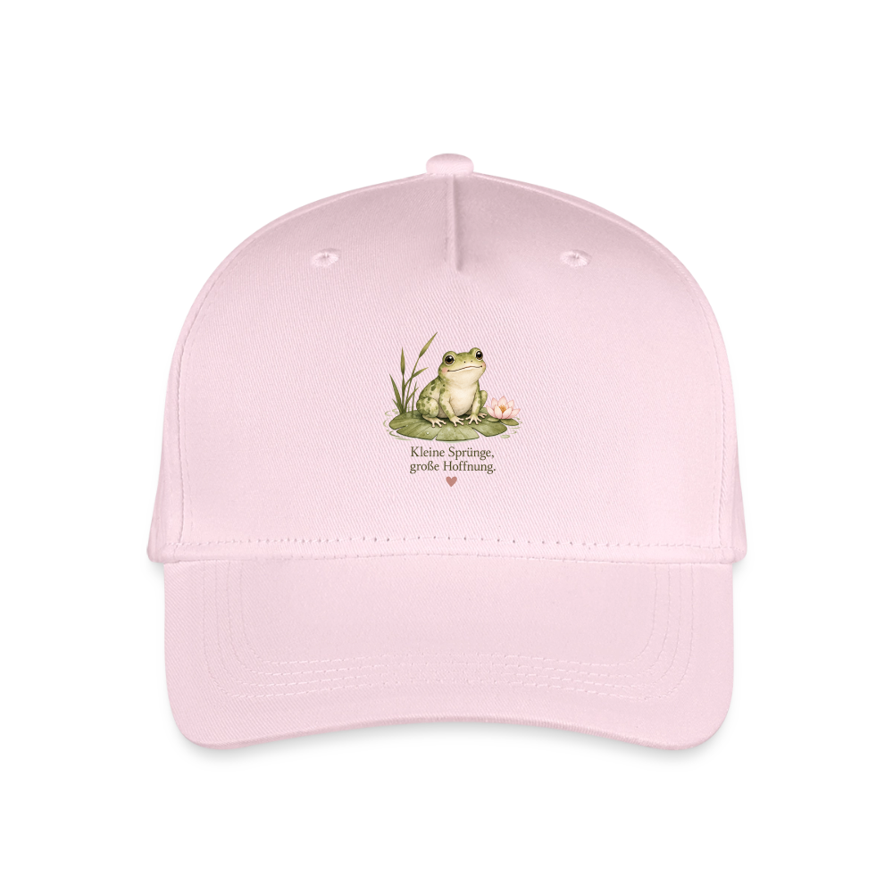 Kinder-Cap in Rosa mit einem niedlichen Frosch auf einem Seerosenblatt und dem Schriftzug „Kleine Sprünge, große Hoffnung“