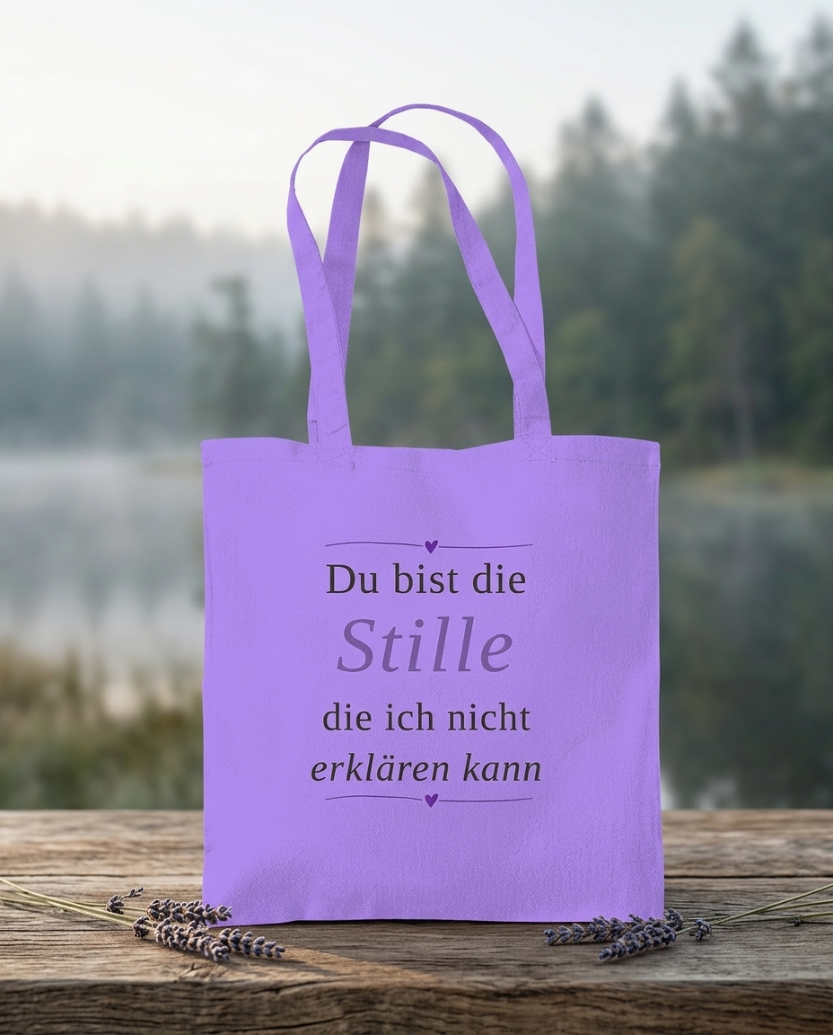 Tragetasche mit Aufdruck Du bist die Stille die ich nicht erklären kann von Wortmelodie Moments auf einem Holzbrett an einem See